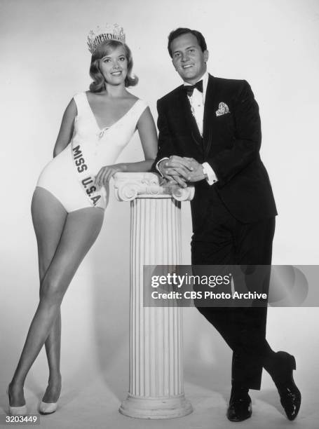 Bobbi Johnson, Miss USA 1964, and American actor and singer Pat Boone lean against a pillar in a full-length promotional portrait for the 'Miss USA...