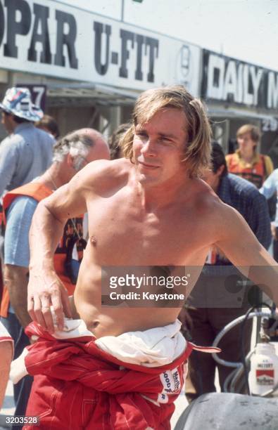 Formula 1 racing driver James Hunt with his overalls pushed down to his waist at the Brands Hatch British Grand Prix.