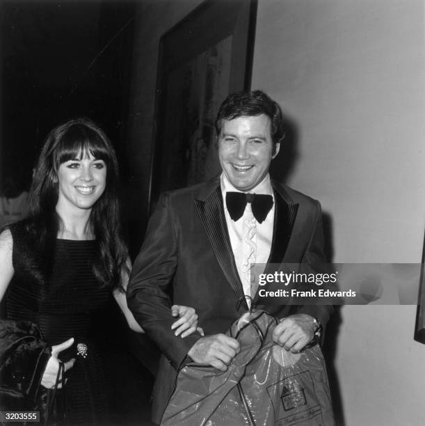 Canadian-born actor William Shatner laughs while carrying a garment bag beside his wife, actor Marcy Lafferty, through a hallway on the opening night...