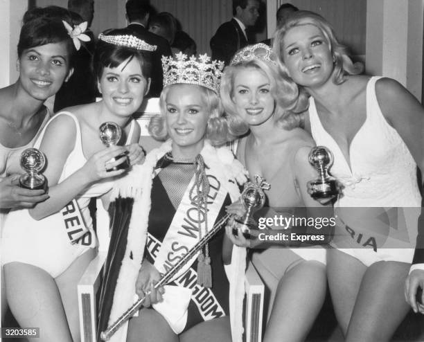 Winners of the Miss World Beauty Pageant pose together after receiving their awards, in the Lyceum Ballroom, London. From left to right, they are...