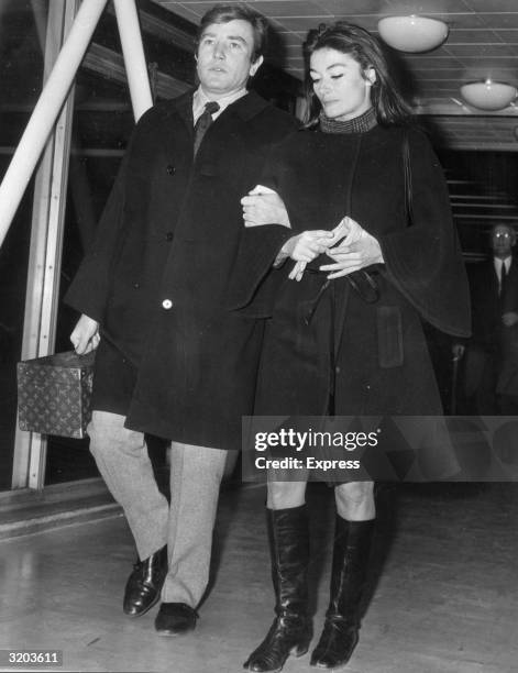 Full-length image of British actor Albert Finney and his girlfriend, French actor Anouk Aimee , walking arm-in-arm at London Airport, England. Finney...