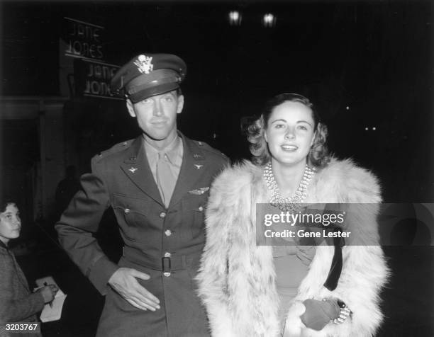 American actor James Stewart and American model and actor Kay Aldridge attend a formal event. Stewart is dressed in his army uniform. Aldridge is...