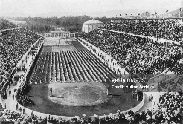 View of athletes, standing in rows, and crowds filling the stadium at the 1896 Olympic Games in Athens, Greece.