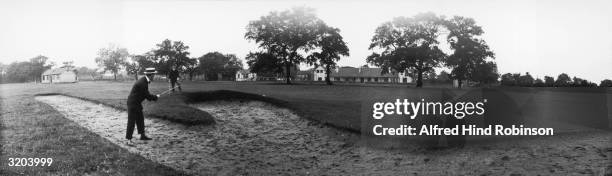 Golfer putting his ball out of a bunker to rest on the green at Harrogate Golf Club. The blurred ball can be seen on the edge of the bunker.