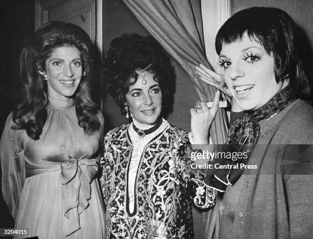 Film star Elizabeth Taylor wearing a £15,000 pearl which belonged to Mary Tudor. She is with dancer, film star and singer Liza Minnelli and Baroness...