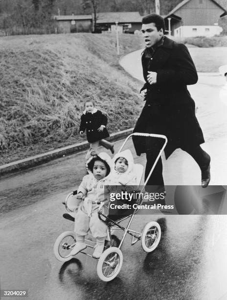 Muhammad Ali trains in Zurich for his fight against the West German Jurgen Blin, with his twin daughters Jamillah and Rasheda.