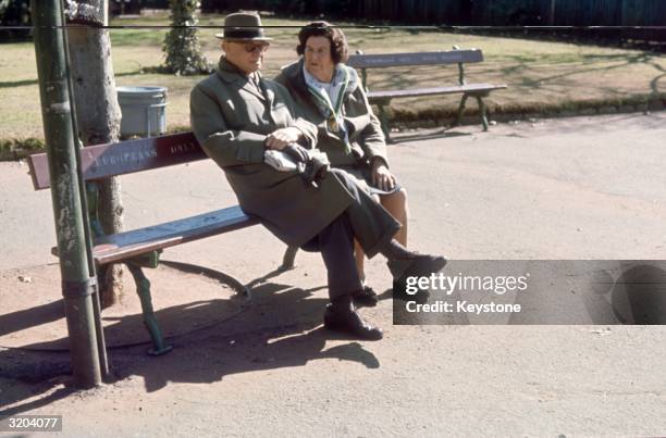 An elderly couple sit on a park bench in Johannesburg. The rules of apartheid reach to even the most innocent scenes as this bench reads 'Europeans...