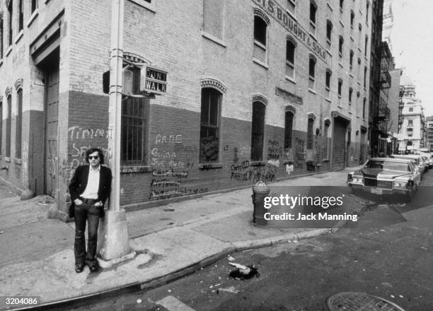Full-length portrait of American director Martin Scorsese leaning against a pole on the corner of Hester and Baxter Streets, one of the locations he...