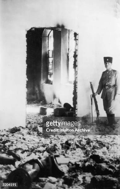 Soldier standing guard in the ruins of a Jewish hospital in Hebron after it was pillaged by Arabs.