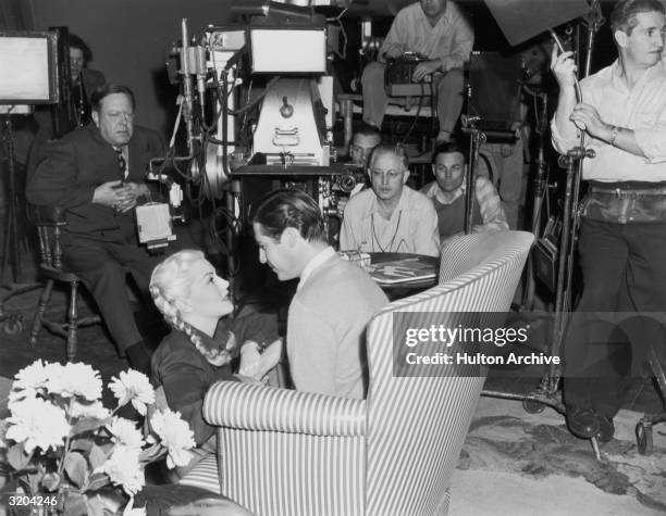 American actor Lana Turner kneels before John Hodiak in front of director Robert Z. Leonard and a film crew, during shooting of Leonard's film,...