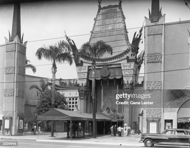 Exterior view of Grauman's Chinese Theater, 6925 Hollywood Boulevard, Los Angeles, California. A couple of people examine the forecourt of the stars,...