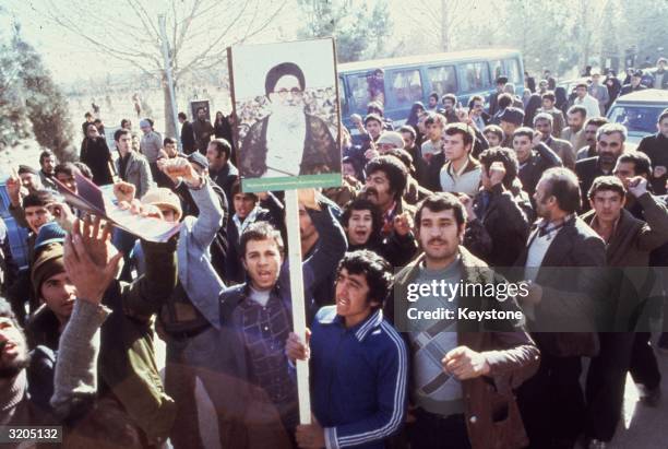 Demonstrators in Teheran calling for the replacement of the Shah of Iran during the Iranian Revolution. They carry placards depicting Ayatollah...