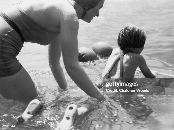 Young girl having a swimming lesson in the sea with her mum.