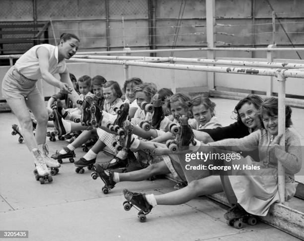 Katherine Snow checks the skates of a group of girls at Battersea roller-rink in Battersea Park, south London, before giving a beginner's lesson in...