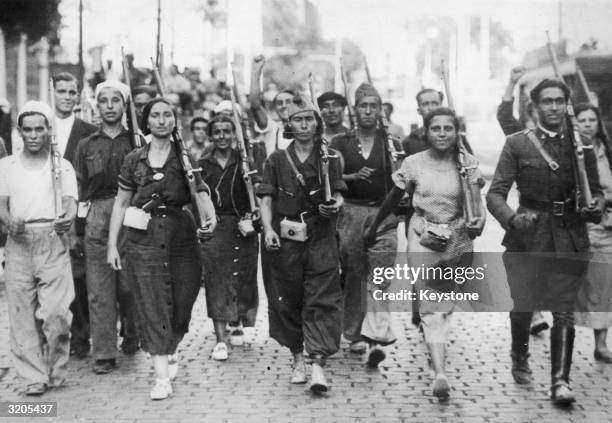 Male and female militia fighters on the march at the beginning of the Spanish Civil War.