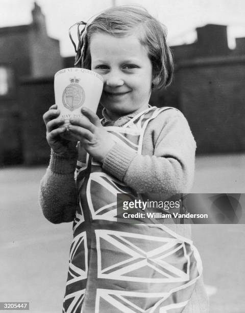 Pupil at Essex Street Infants School in east London with her Coronation gift mug, given to the children by London County Council to mark the...