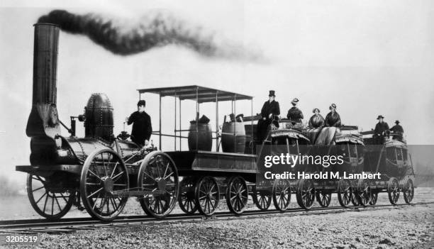 An early English steam locomotive hauling a tender and three carriages adapted from horse-drawn coaches.