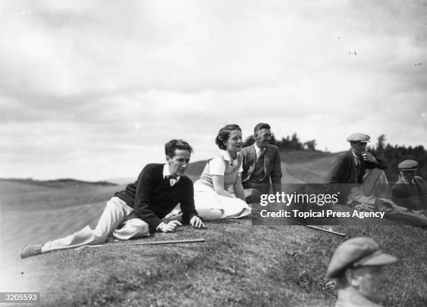 Film actress Norma Shearer and her husband, producer Irving Thalberg relax in the rough during a game of golf at Gleneagles Hotel, Perthshire.