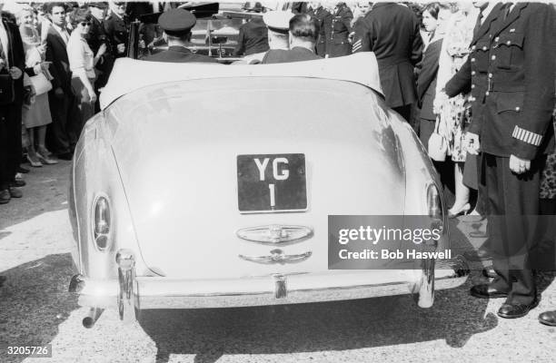 Russian cosmonaut Yuri Gagarin driving through the streets of London in a convertible with a personalised number plate 'YG 1'.