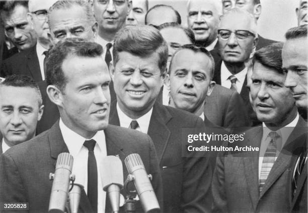 American astronaut Gordon Cooper speaks in front of microphones as U.S. President John F. Kennedy and astronauts Gus Grissom, Alan Shepard, Walter...