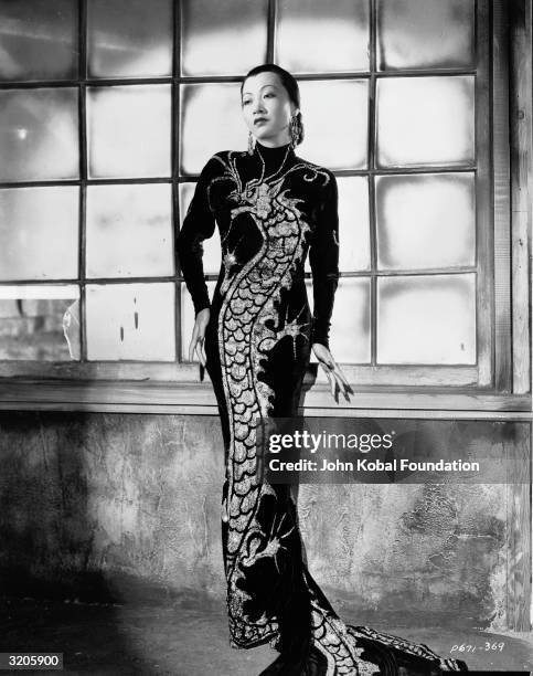 Chinese-American film star, Anna May Wong wearing a dress with dragon motif in a publicity shot for 'Limehouse Blues', directed by Alexander Hall.