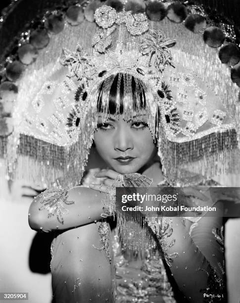 Chinese-American film star, Anna May Wong wearing an outlandish headdress.