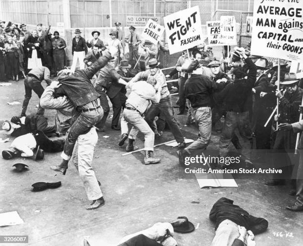 Scene depicting unionized strikers fighting with a group of 'scabs' or nonunion replacement employees as they try to cross the picket line at a...