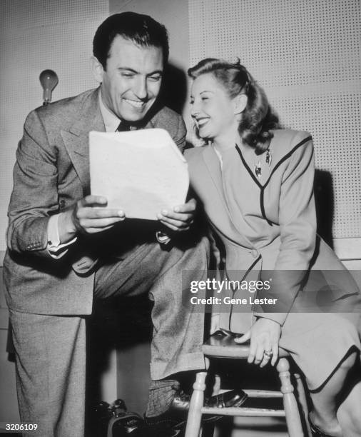 American jazz bandleader Eddy Duchin looks over a packet of papers with American jazz singer Martha Tilton.