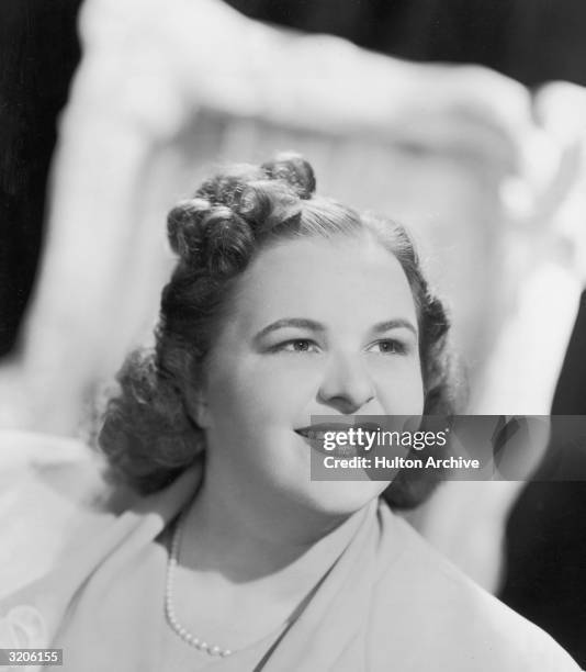 Headshot portrait of American vocalist Kate Smith smiling.