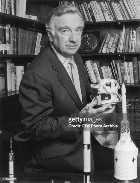 American broadcast journalist Walter Cronkite holds a model of a U.S. Lunar module in a promotional portrait for CBS News' coverage of a joint...