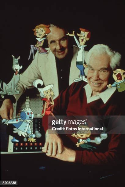 Studio portrait of American animators Joseph Barbera and William Hanna posing with members of the cartoon family, 'The Jetsons'.