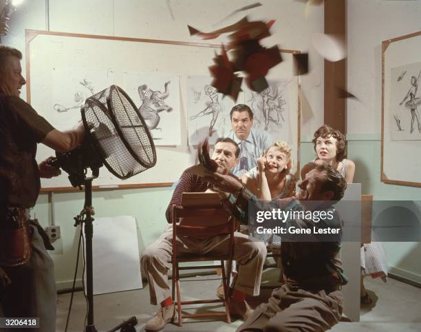 Animators from Walt Disney Studios watch as a man demonstrates a flying motion exercise with a fan, Disneyland, Anaheim, California. The walls of the...