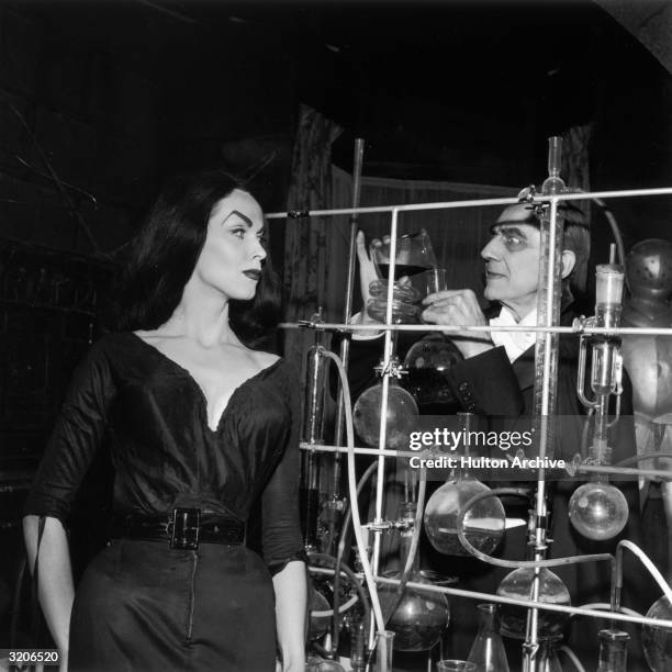 Austrian-Hungarian-born actor Bela Lugosi pours a chemical into a test tube as Finnish-born actor and television host Vampira looks on beside an...