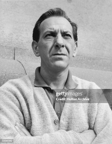 American actor Jack Klugman stands in front of a wall with his arms folded in a promotional portrait for the television series, 'Harris Against the...