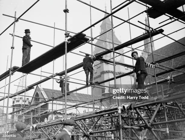 Workmen erecting stands for sightseerers around Parliament Square in preparation for the coronation of George VI.