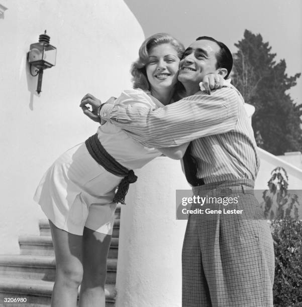 American actor Lana Turner smiles as she hugs Jimmy Sarno of the MGM Studios publicity department at her Sunset Plaza apartment complex, Los Angeles,...