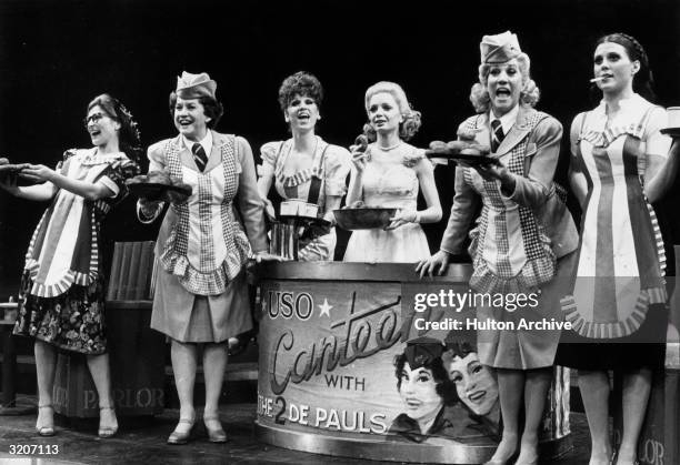 Actors Phyllis Somerville, Maxene Andrews, Marilu Henner, April Shawhan, Patty Andrews, and Ann Reinking sing on stage in a production number set in...