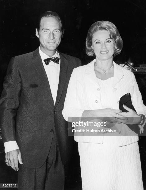 American comedian Sid Caesar and his wife, Florence Levy, smile as they attend the premiere of director Basil Dearden's film, 'Khartoum,' New York...