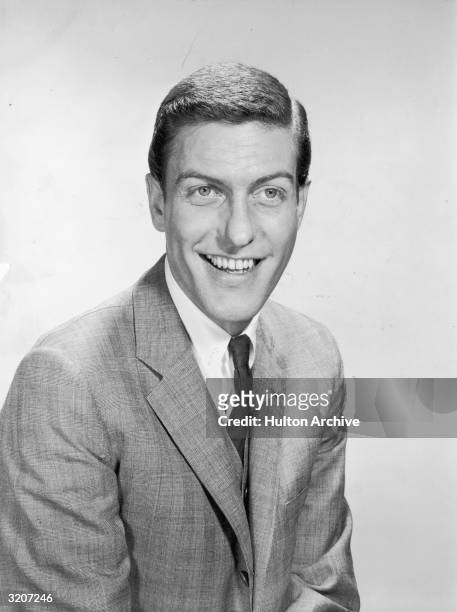 Portrait of American comedian and actor Dick van Dyke smiling in a suit and tie.