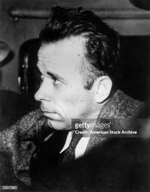 Headshot of American criminal John Dillinger riding in a plane with an escort, en route to Indiana to answer charges of murder of a police officer...