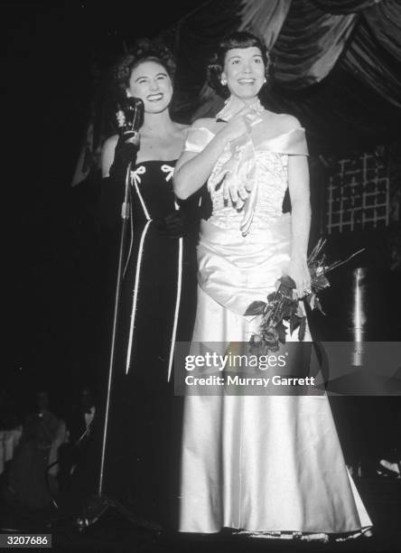 American actor Jane Wyman and American cabaret singer Hildegarde stand together at the premiere of director Jean Negulesco's film, 'Johnny Belinda,'...