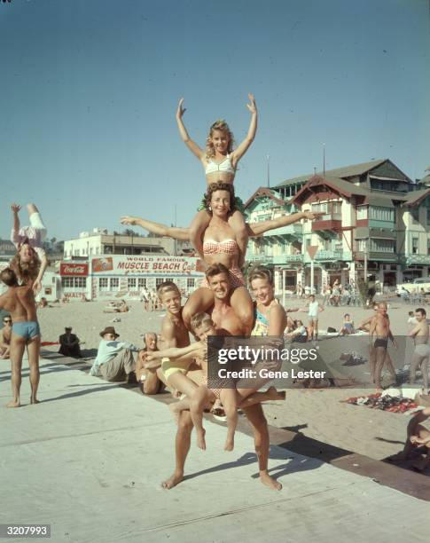 The Ferges family of stunt performers balancing at Muscle Beach, Santa Monica, California, 1956. Father is Ron Ferges. In front is Terry, four years...