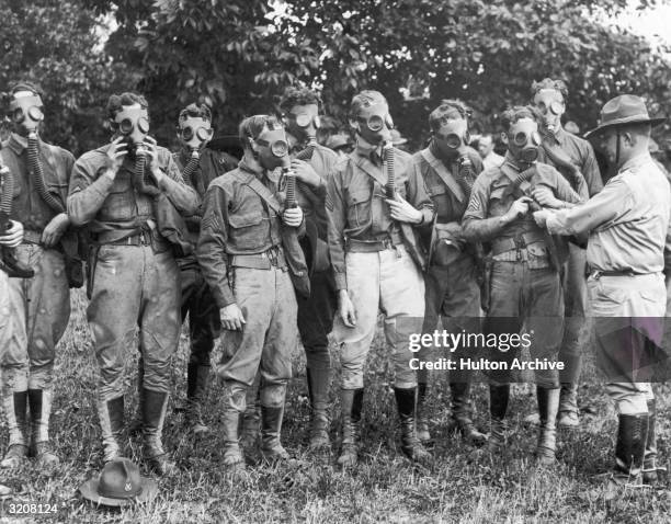 Pennsylvania National Guardsmen receiving instructions from a chemical warfare service officer in the use of gas masks during World War I.