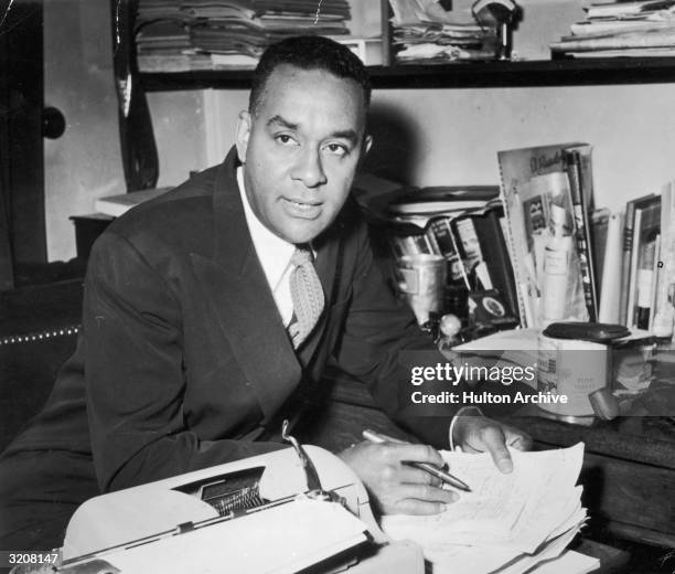American author Richard Wright sits at a desk with a pen in his hand shortly before the publication of his book, 'White Man, Listen!,' Paris.