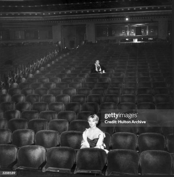 French actor Brigitte Bardot sits in a nearly empty movie theater.