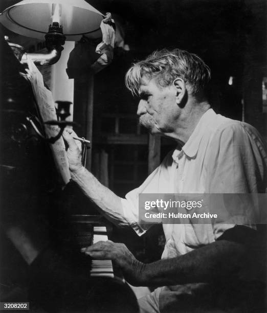 Portrait of German-born humanitarian and Bach scholar Albert Schweitzer composing at his custom-made zinc-lined piano, designed for the climate of...