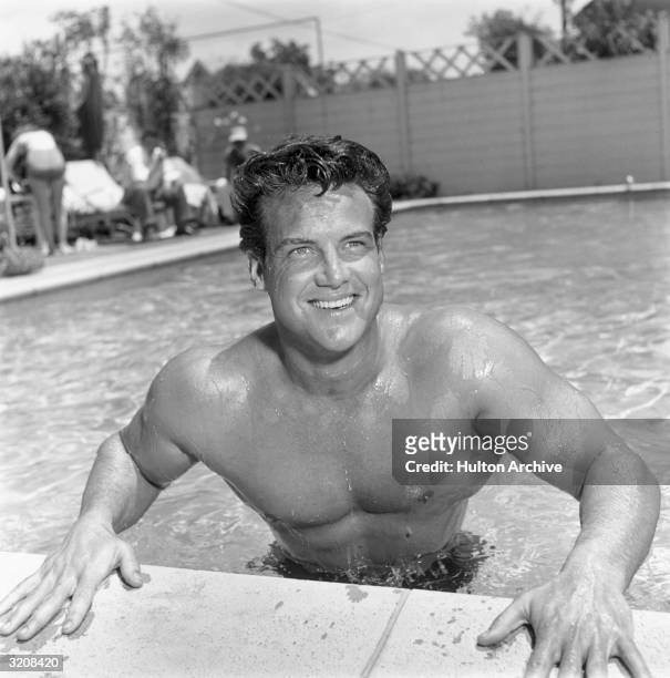 Bodybuilder and winner of one Mr. America and two Mr. Universe titles, Steve Reeves , smiles at the edge of a swimming pool.