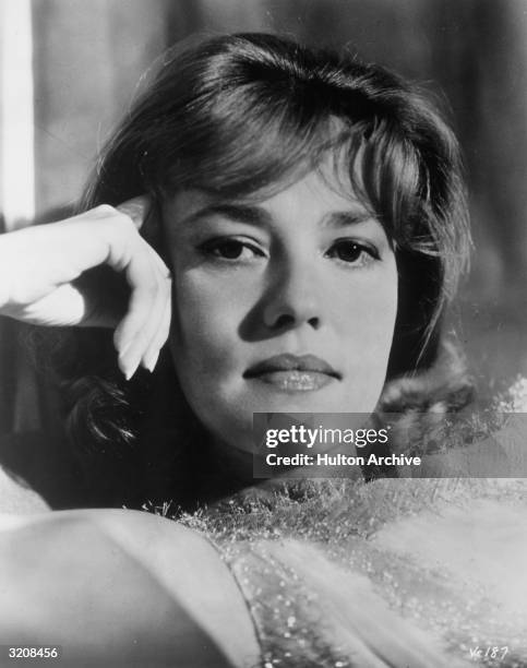 Headshot of French actor Jeanne Moreau holding her hand to her temple.