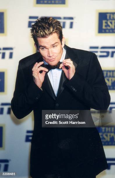 Lead singer Mark McGrath of the American rock bank Sugar Ray, wearing a tuxedo, adjusts his bow tie as he stands in front of a wall of logos at the...