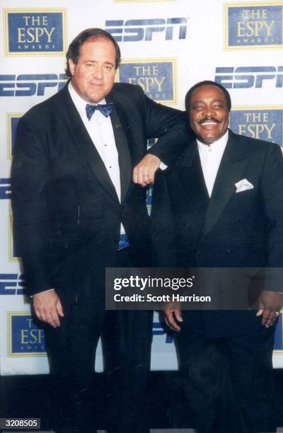 Football commentator Chris Berman rests his shoulder on ESPN baseball analyst and National Baseball Hall of Famer Joe Morgan's shoulder at the eighth...